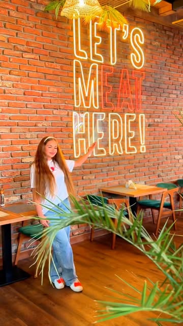 Interior Bistro Miraj cu perete din cărămidă și neon